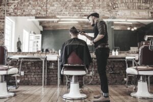 barber cutting his clients hair on a barber chair